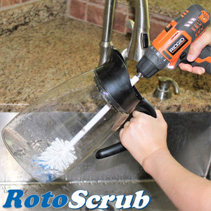 An extended reach bottle brush, attached to a Rigid drill, cleaning a beverage pitcher in the kitchen sink..